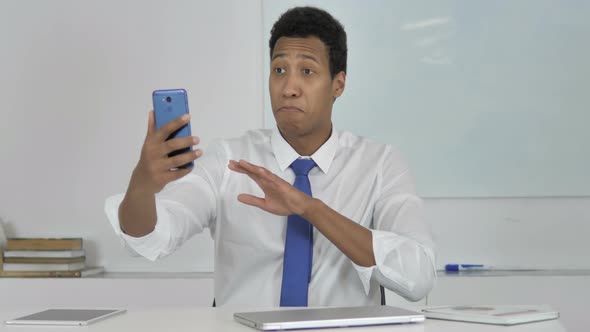 Online Video Chat By Afro-American Businessman Via Smartphone alt