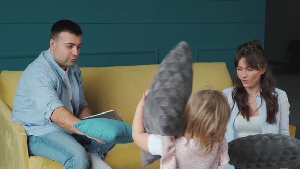 Little Girl Playing with Her Parents with Pillows Enjoy the Time Spending Together alt