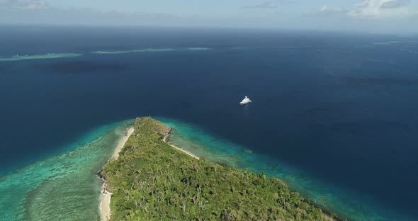 Aerial footage of ocean and land on an island in Tonga. Wide angle, vast ocean view alt