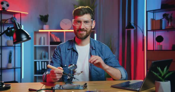 Bearder in Protective Glasses Looking at Camera with Gesturing Ok alt