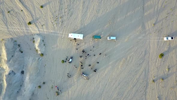 overhead spiral shot of buses and people in the Namibian desert alt