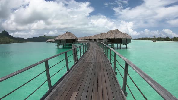Walking down pathway by overwater bungalows Bora Bora, French Polynesia. alt