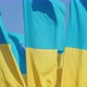 the Flag of Ukraine a Silk Flag Waving Against the Background of the Setting Blue Sky on a Large