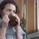 Sick female in a scarf drinks tea with lemon. - VideoHive Item for Sale