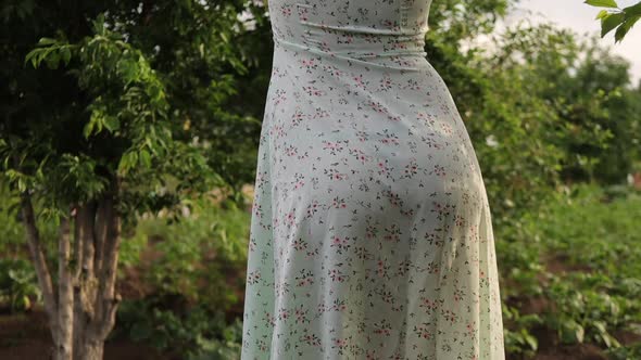 Woman Walking in Garden with Green Plants