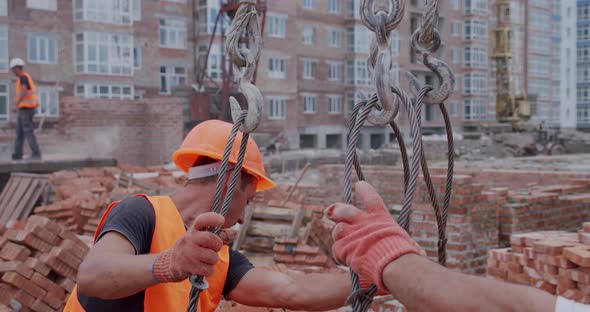Construction Workers Attach Materials To the Crane alt