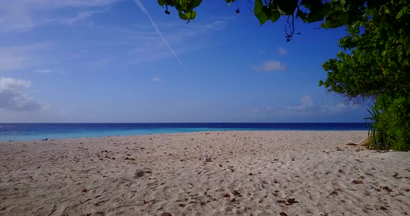 Daytime overhead travel shot of a white paradise beach and blue water background in 4K alt