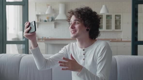 Video of a Handsome Young Man Making Video Call From Home Waving Hand alt