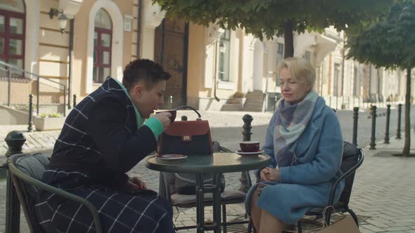Mature Female Partners Holding Business Meeting Drinking Hot Beverages alt