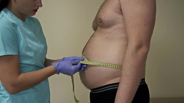 Doctor Measures the Abdominal Circumference of an Overweight Patient alt