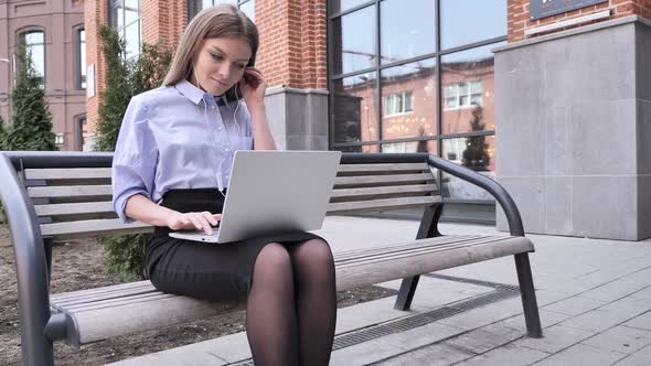 Woman Listening Music and Enjoying Outside Office Building Laptop alt