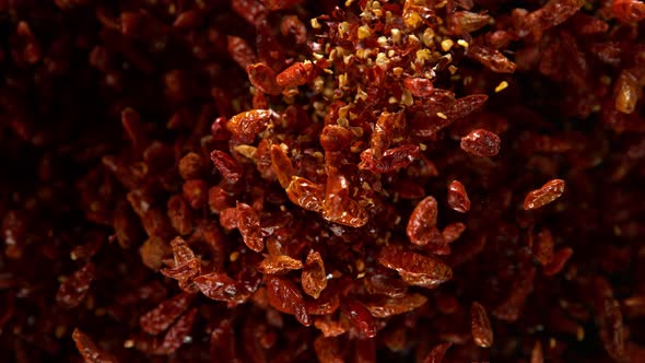 Super Slow Motion Shot of Dried Red Chili Peppers Explosion on Black Background at 1000Fps. alt