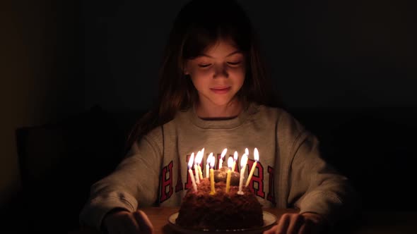 Small Young Teen Girl Blows Out the Candles on the Cake on Her Birthday