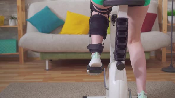 Closeup of a Leg on a Stationary Bike Knee Bend Orthosis Knee Brace After Injury alt