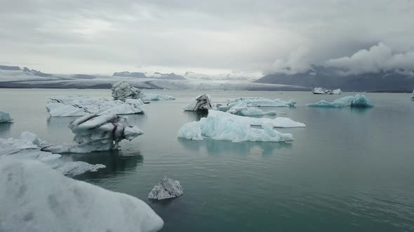 A drone footage of a boat in between the icebergs alt