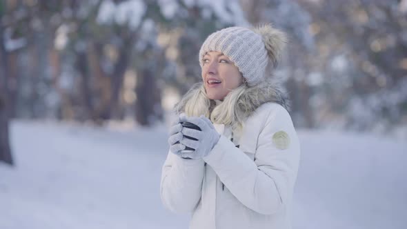 Portrait of Cute Girl in Warm Winter Clothes Drinking Hot Coffee From a Cup alt