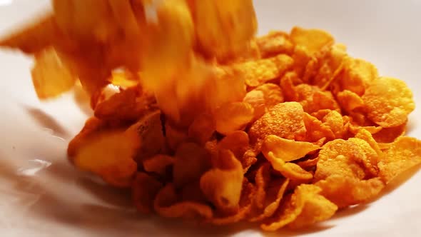 Pouring Delicious Yellow Cornflakes in White Plate in Macro and Slow Motion alt
