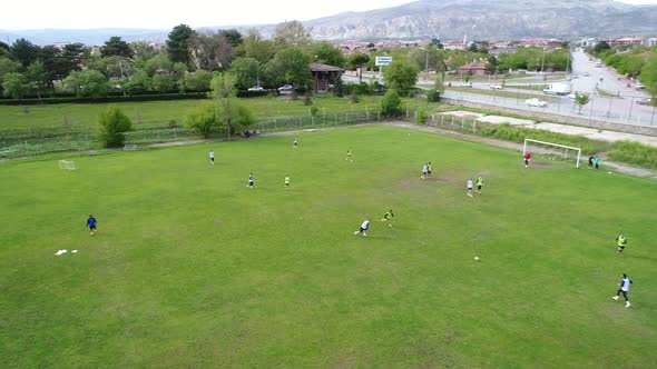 Boys playing soccer, training on football field.