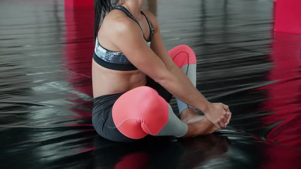 Unrecognizable Young Woman Sitting on Floor in Lotus Butterfly Yoga Pose at Gym alt