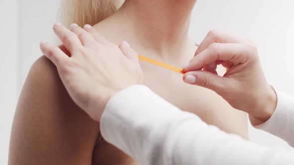 Therapist is applying kinesio tape to female face. Kinesiology and recovery treatment. alt