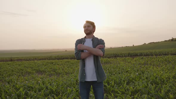 Young Smiled Man Looks on His Crops alt