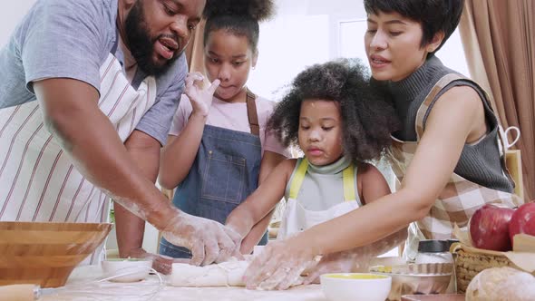 Kids and family preparing flour to make bread in kitchen at home.