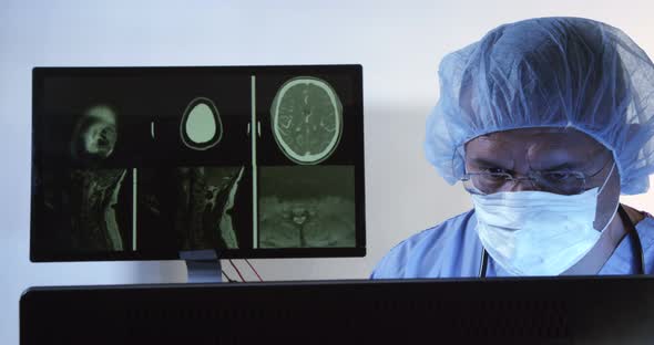 Doctor Sitting At The Desk With X-rays On The Monitor 16