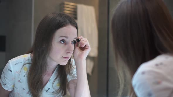A Girl Applies Makeup in the Bathroom Before a Business Meeting alt