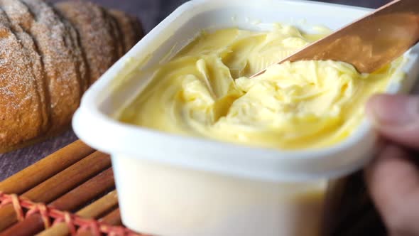 Fresh Butter in a Container with Bread on White Background alt