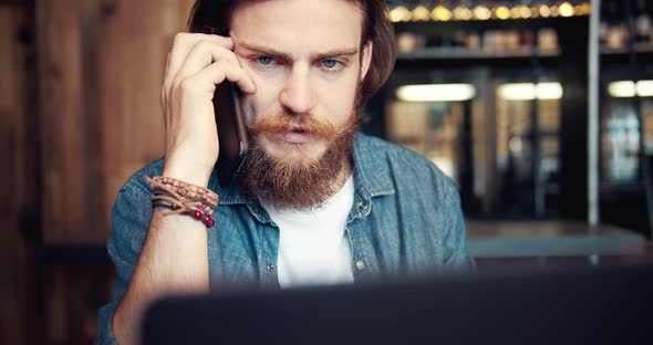 Busy Man with Smartphone and Laptop in Cafe