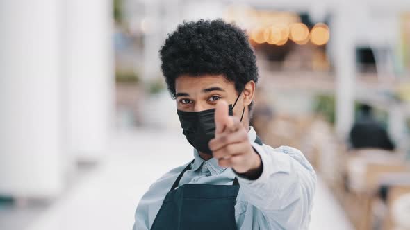 Friendly African Masked Guy Male Waiter Salesman Man in Medical Face Protective Mask Restaurant Cafe alt