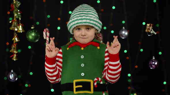 Christmas wish concept Kid teen girl in Christmas elf Santa helper costume making a wish, prays alt