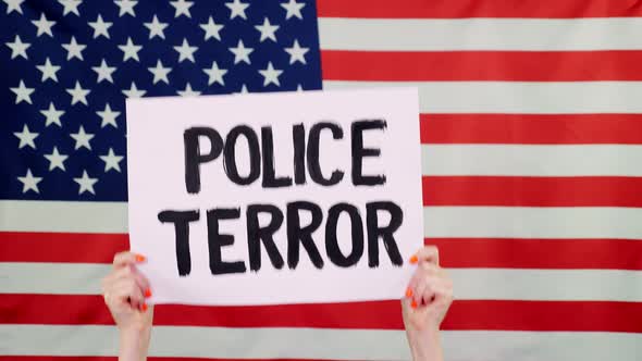 Protester Holds a Banner with a Slogan - Police Terror - Against Background of the USA Flag alt