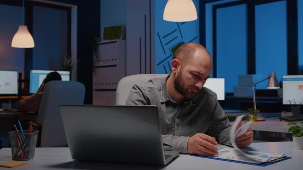 Exhausted Workaholic Businessman Analysing Marketing Statistics Sitting at Desk Table alt