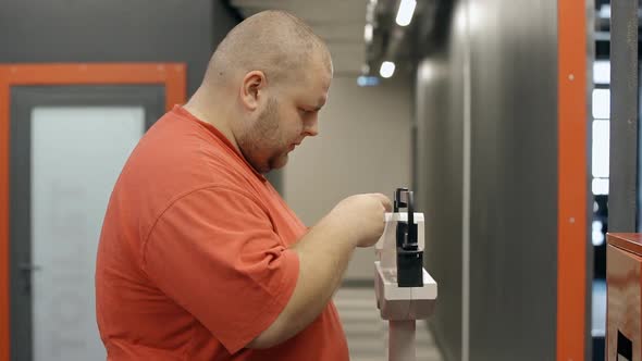 Overweight Man Adjusting Medical Scale in Gym Checking Weight Loss After Workout