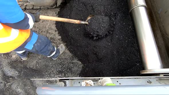 Worker Is Laying Asphalt. Road Works on a Construction Site. The Distribution of the Asphalt with a
