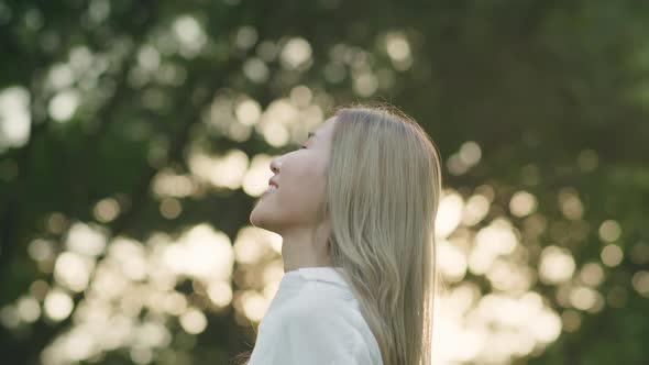 Asian woman closed her eyes enjoying the breeze in the public park.