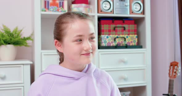 Teen Girl is Playing Guitar and Smiling alt