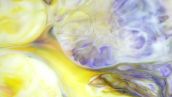 Ink in Water. Yellow and Violet Ink Reacting in Water Creating Abstract Background