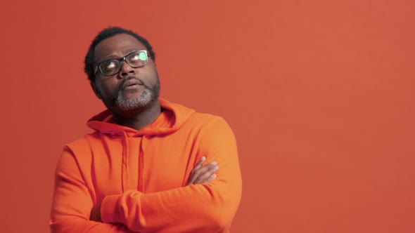 Displeased mature African man spreading his hands alt