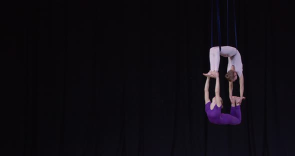 Performance on Stage Two Girls Doing Aerial Gymnastics Spinning in the Air alt