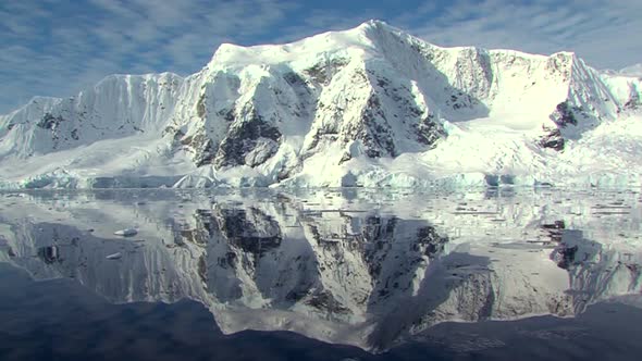 Antarctic landscape with perfect reflection and sun