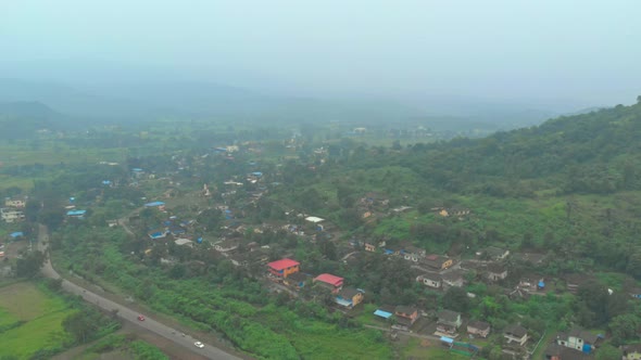 rotating drone shot over rural Indian village on hillside alt
