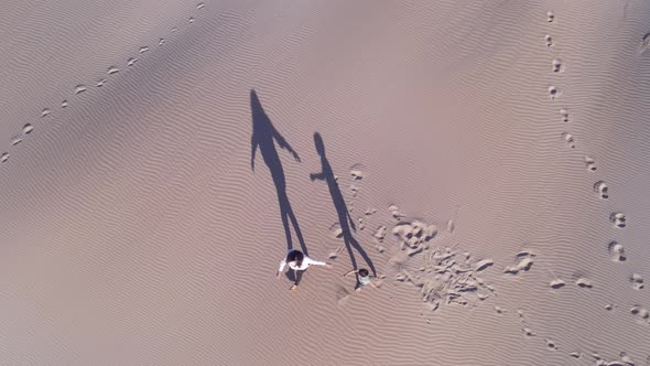 Aerial View of Mum and Son Walking Along Dunes