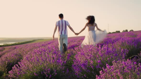 A Happy Couple in Love Runs on a Lavender Field