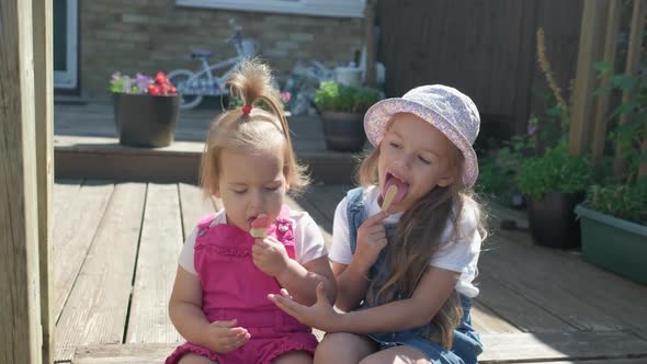 Two Sisters Children Enjoys Delicious Ice Cream Cone