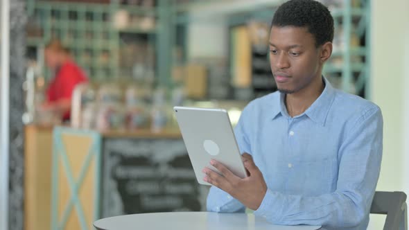 Professional Young African Man Using Tablet in Cafe  alt