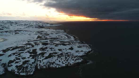 A Beautiful Sunset Over the Shore of the Arctic Ocean Covered with Snow a Storm is Approaching the