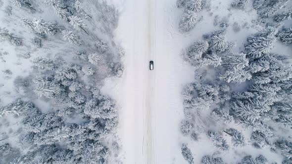 Car Traveling On A Snowy Road In The Forest
