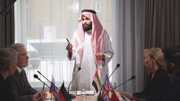 Portrait of Serious Young Arabic Man Wearing Traditional Emirates Clothes on Meeting